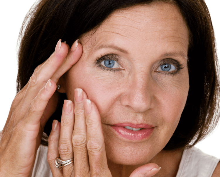 Middle aged women looking in mirror with hands on face