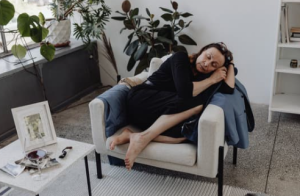 a women is sitting slumped over in a chair as is sleeping, looks exhausted