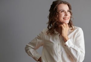 middle aged women looked up and to the right,curly hair and smile on her face