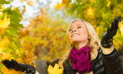 happy Women with fall foliage behind her,